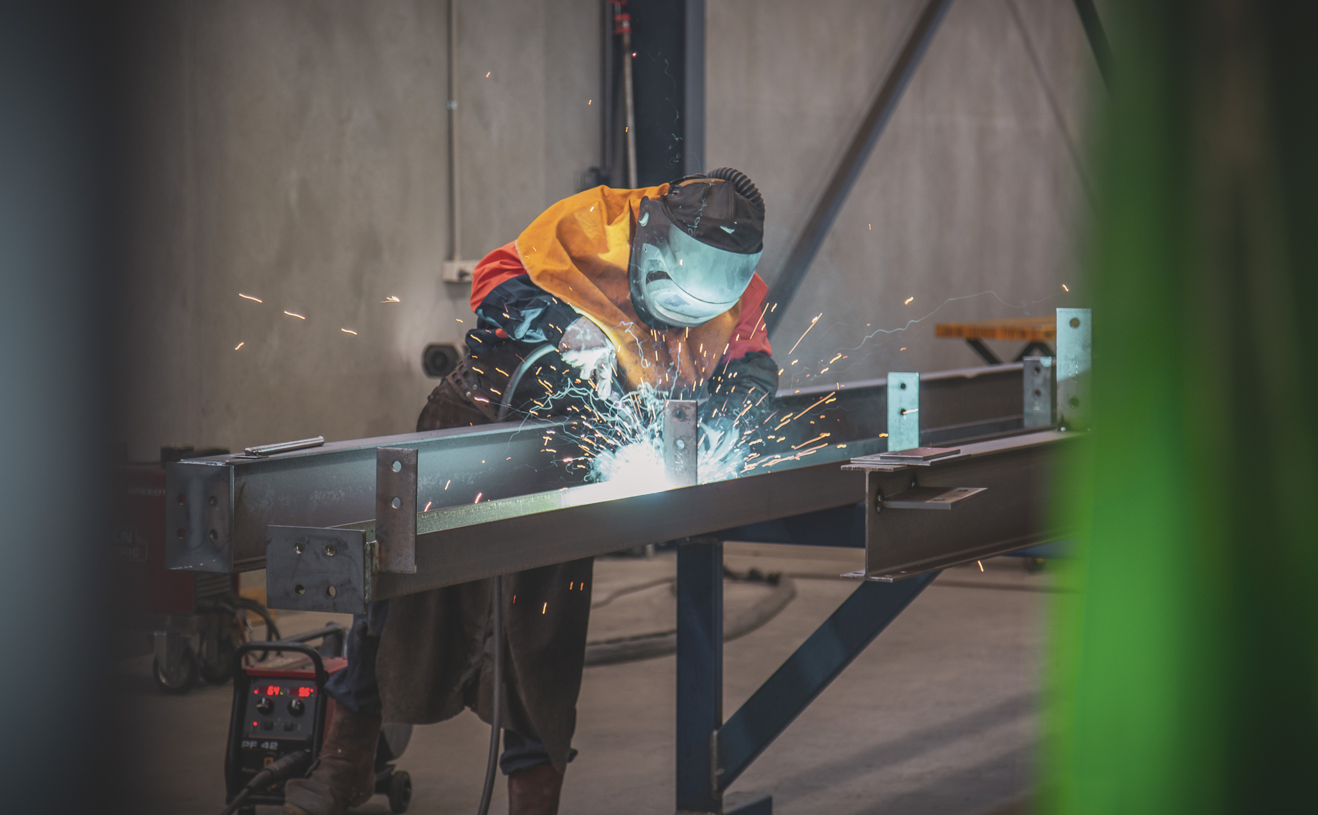 man cutting engineered steel in factory